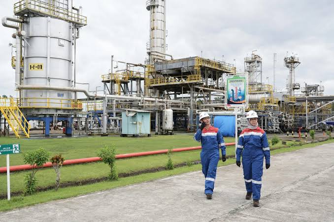Dua pekerja migas berjalan di area kilang minyak milik Pertamina. Foto: Dok. BPH Migas.