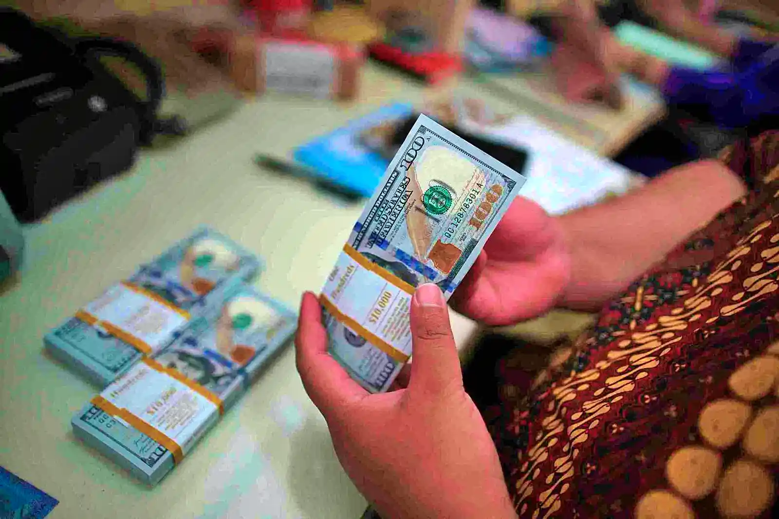 Pegawai menghitung uang dolar AS (USD) saat melayani pengunjung yang menukarkan mata uang di La Tunrung Money Changer, Juanda, Selasa, 11 Maret 2025. (Foto: KabarBursa/Abbas Sandji)