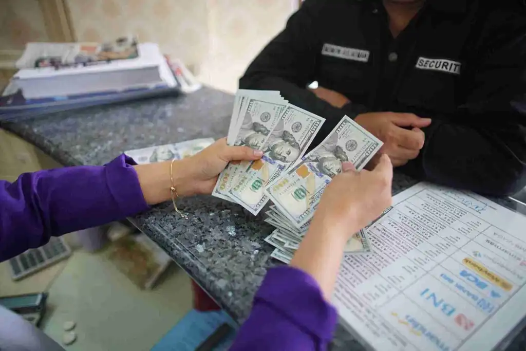 Seorang nasabah menghitung uang dolar AS di sebuah tempat penukaran valuta asing di Jakarta. Kinerja nilai tukar dan pergerakan dolar menjadi indikator penting dalam merespons kebijakan suku bunga The Fed dan tarif perdagangan global. Foto: KabarBursa/Abbas Sandji.