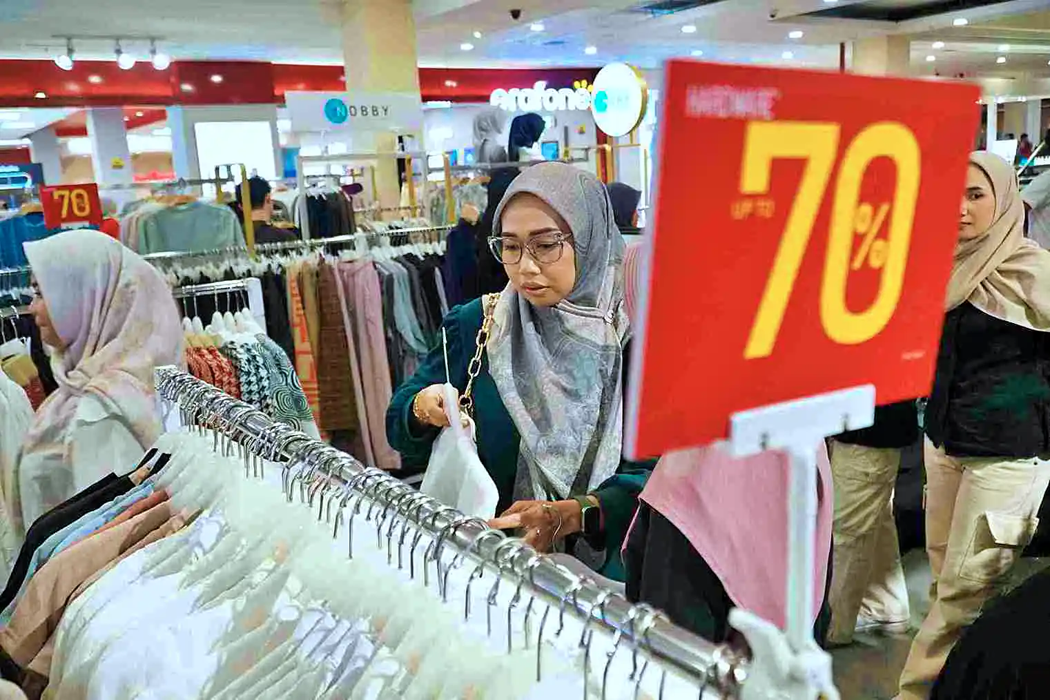 Ilustrasi: Pengunjung memperhatikan deretan pakaian bertanda diskon 70 persen di sebuah pusat perbelanjaan. (Foto: KabarBursa/Abbas Sandji)