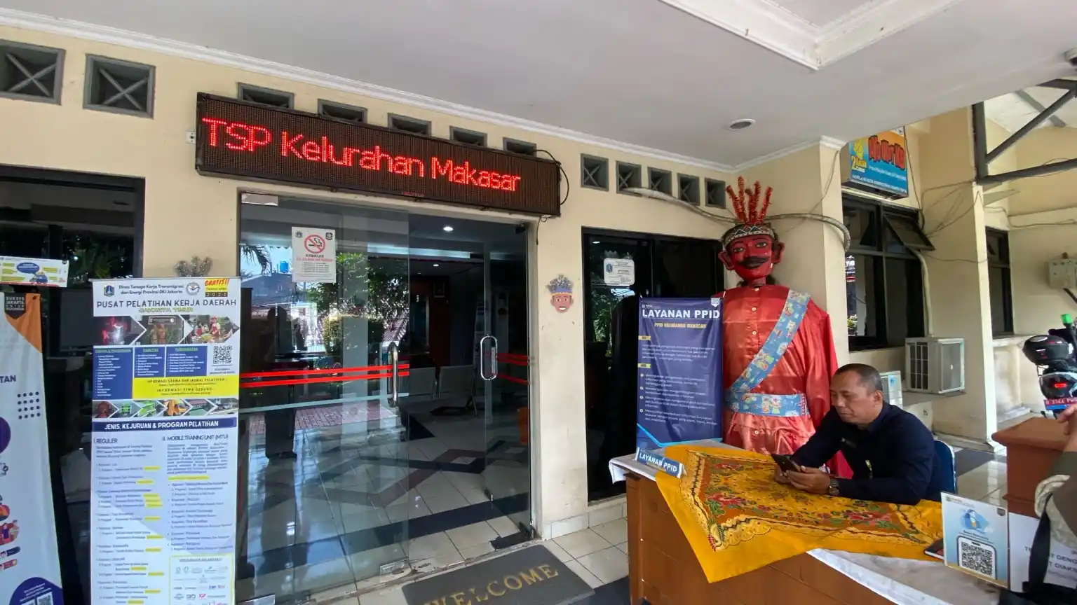 Seorang petugas berjaga di lobi Kantor Kelurahan Makasar, Jakarta Timur, yang kini menjadi salah satu kelurahan perkotaan pertama yang menjalankan program Koperasi Desa (Kopdes) Merah Putih. Program ini ditujukan untuk memperkuat distribusi sembako dan barang subsidi bagi warga. Foto: KabarBursa/Dian Finka.