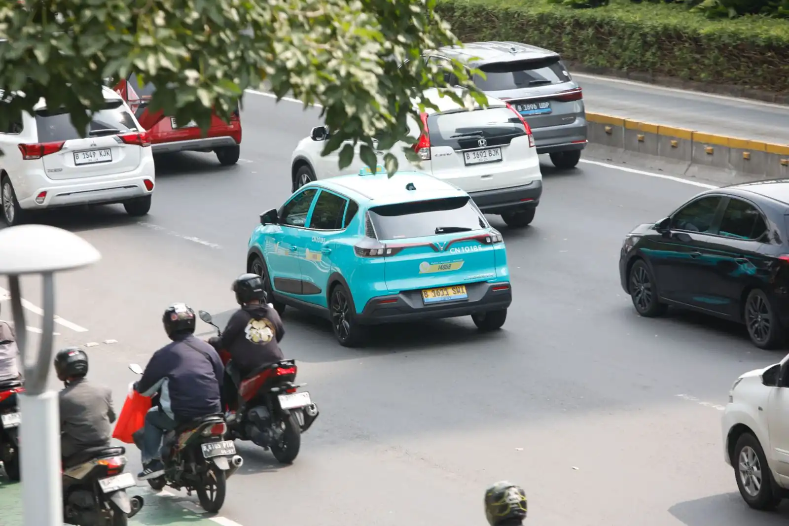 Sejumlah kendaraan bermotor, termasuk taksi listrik dan sepeda motor konvensional, melintas di salah satu ruas jalan protokol Jakarta. Pemerintah didorong untuk mempercepat adopsi kendaraan listrik demi menurunkan emisi sektor transportasi dan mengurangi ketergantungan pada bahan bakar fosil. Foto: KabarBursa/Abbas Sandji.